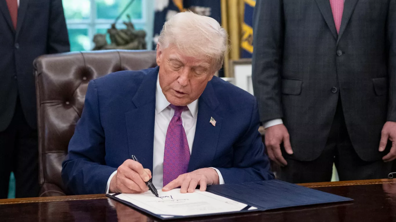 Donald Trump firmando 25